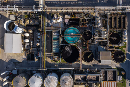 Aerial view of an industrial wastewater treatment plant featuring circular tanks, complex piping systems, and storage silos in Nera Montoro, Umbria, Italy.