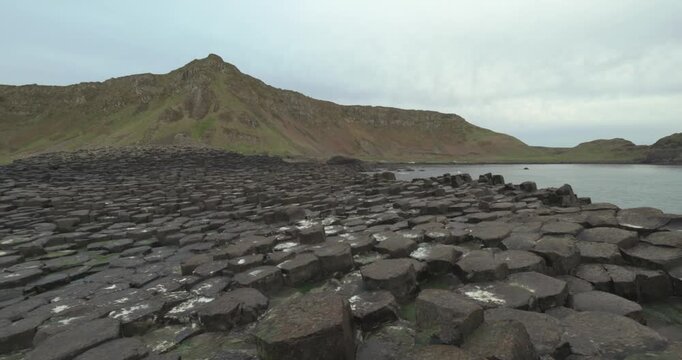 Panoramic view of hexagonal basalt columns at Giants Causeway coastal landscape on overcast day cinematic travel footage.