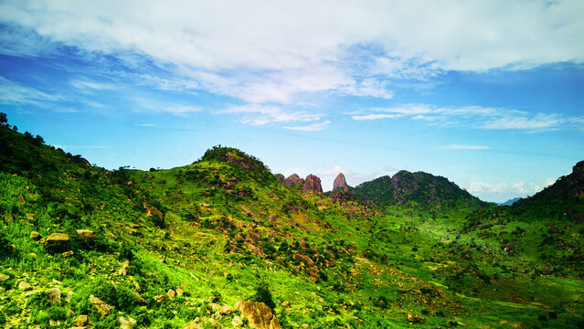 Aerial view of the rocky hills and lush green landscape of the Dass region under a bright blue sky in Bauchi, Bauchi, Nigeria.