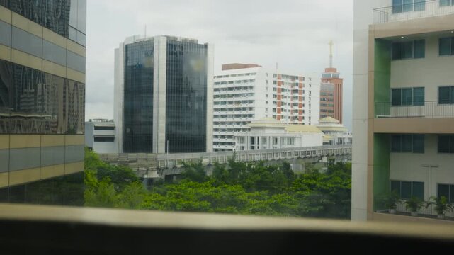 Defocused time-lapse of BTS skytrain between condo towers in Bangkok
