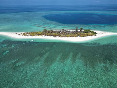 Aerial view of Pulau Ndaa, a small tropical island with white sand beaches, surrounded by turquoise coral reefs and deep blue sea in Tomia, South East Sulawesi, Indonesia.