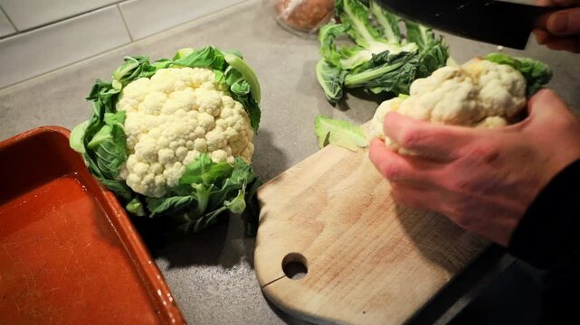 Stockholm, Sweden A cook in a residential kitchen cuts cauliflower into florets and puts them in a grilling dish for the oven. 