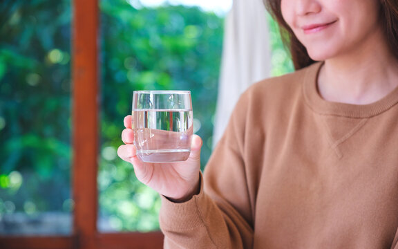 Closeup image of a woman holding a glass of drinking water