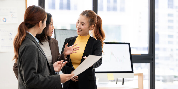 Asian Businesswomen Discussing Project and Gesturing in Modern Office