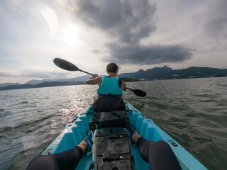 Obraz premium Young male traveler rowing a boat over the sea surface
