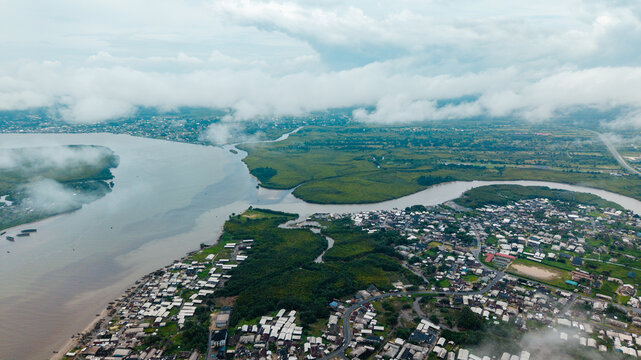 Aerial view of the Kwa Ibo River estuary flowing into the Atlantic Ocean, featuring lush mangroves and coastal residential areas in Kwa Ibo, Akwa Ibom, Nigeria.