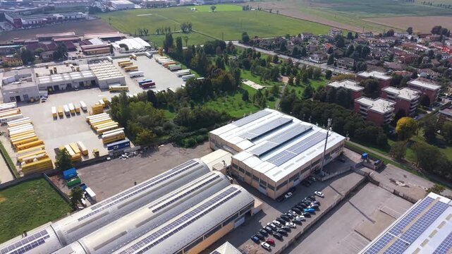 Industrial Park Aerial View: An expansive industrial park complex showcasing modern warehouses, logistical operations, and solar panel installations.