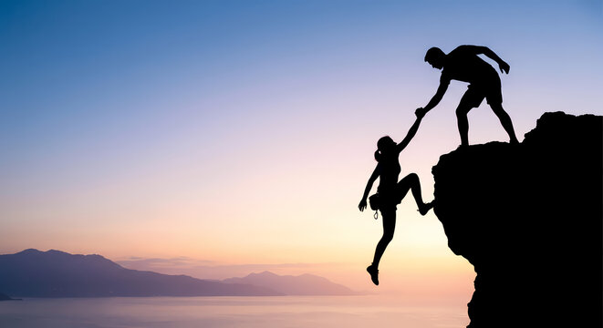 A dedicated climber reaches out to help a partner ascend a steep rocky cliff during a glowing sunset to demonstrate the power of teamwork and mutual support for achieving difficult shared life