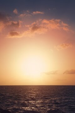 Golden Sunset Over the Ocean with Glowing Clouds and Calm Horizon
