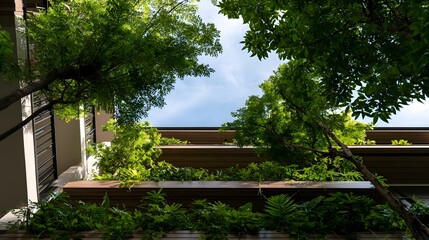 Fototapeta premium A lush green balcony garden framed by tree branches and wooden railings under a clear blue sky
