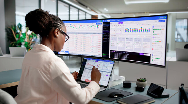DevOps Engineer Carefully Monitors Pipeline Status Using Laptop