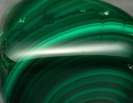 Polished green malachite gemstone texture with dark concentric banding