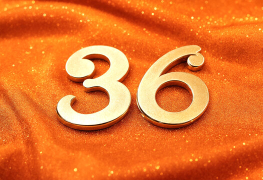 Golden metallic numbers thirty six on glittery orange background