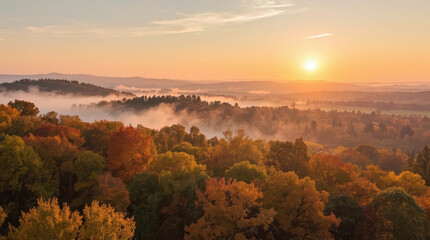 Fototapeta premium Autumn forest sunrise over misty hills with colorful foliage