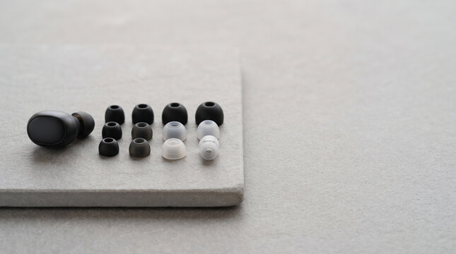 Black wireless earbuds with a variety of interchangeable silicone ear tips arranged in rows ad social media download thambnail poster web template event festival 2026 2027 2028