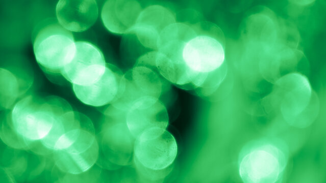 Bokeh. Holiday background. Christmas lights. Glitter. Defocused sparkles. New Year backdrop. Festive wallpaper. Blinks. Carnival. Tinsel. Bokeh retro style photo. Green.