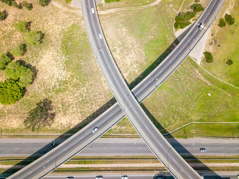 Aerial view of the highway interchange in Brackenfell with vehicles driving on the roads surrounded by green fields in Cape Town, Western Cape, South Africa.