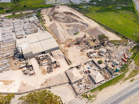 Aerial view of the industrial site in Philippi with piles of sand and gravel, heavy machinery, and storage facilities in Cape Town, Western Cape, South Africa.