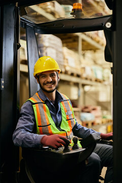 Happy forklift operator at work looking at camera.