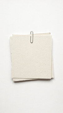 Small pile of textured paper sheets held by metal paperclip with stationery recycled fastener material business background organizer workshop resource template as isolated PNG