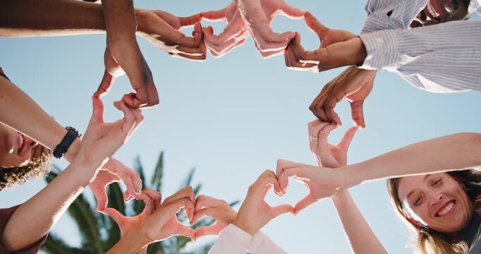 People, unity or friends with heart hands in park for love, social cohesion or solidarity. Low angle, group or community with romantic gesture, shape or emoji for outdoor passion, charity or donation