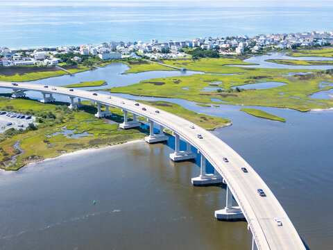 Aerial view of North Topsail Bridge spanning the marshlands and coastal waters with cars driving across the structure in North Topsail Beach, North Carolina, United States.