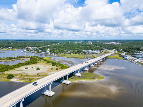 Aerial view of North Topsail Bridge spanning the waterway with surrounding marshlands, coastal vegetation, and scattered buildings in North Topsail Beach, North Carolina, United States.