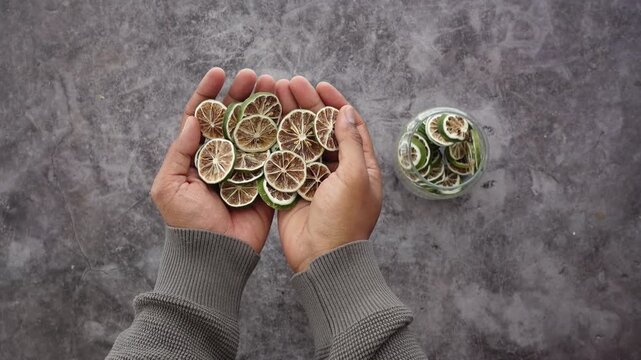 Hand holding dried lime slices over textured background, close up cinematic footage