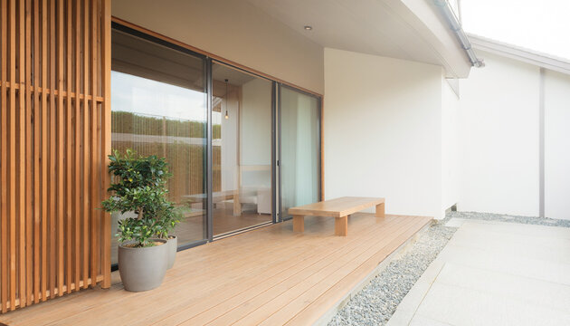 木製デッキと格子を備えた明るい和モダン住宅の縁側