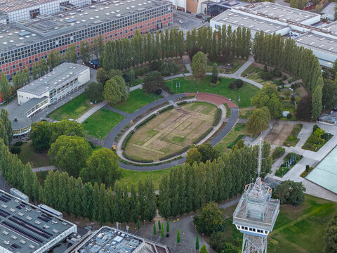 Aerial view of the Sommergarten event space at Messe Berlin, featuring the iconic Radio Tower, lush green trees, and surrounding exhibition halls in Berlin, Berlin, Germany.