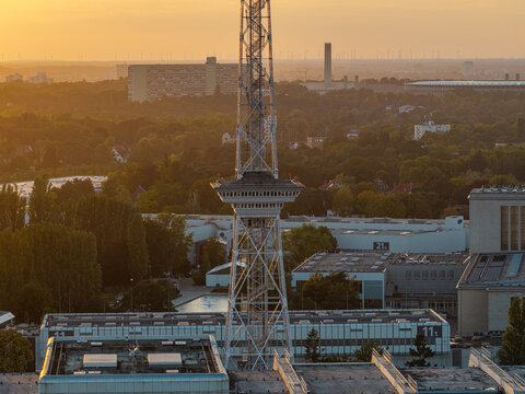 Aerial view of the ICC Berlin, a prominent example of Brutalist architecture, featuring its metallic tower and geometric structures bathed in golden hour light Berlin, Berlin, Germany.