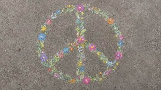 Colorful chalk drawing of a peace symbol surrounded by vibrant flowers on a textured concrete surface, showcasing artistic expression and creativity in outdoor art