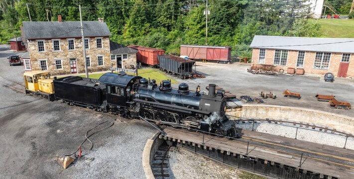 Aerial view of a historic black steam locomotive on a turntable at the East Broad Top Railroad in Rockhill, Pennsylvania, United States.