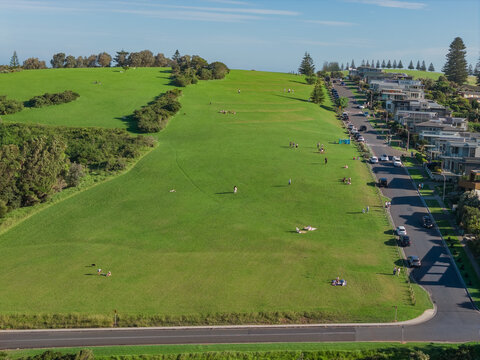 Aerial view of a winding road on a sloping green hillside