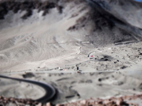 Tilt shift photo of a winding road in a barren landscape