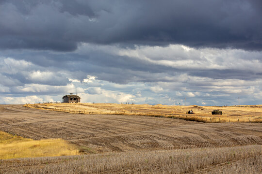 Abandoned schoolhouse on a prairie under stormy clouds