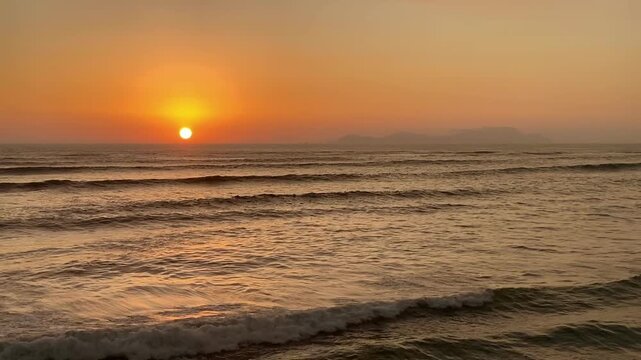 Golden sun setting over the tranquil ocean waves