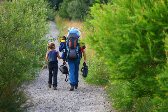 Woman and young daughter hiking on a gravel trail