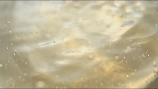 Advanced bio-based surfactant solution appears as a translucent muted pale-yellow liquid with tiny abstract material background