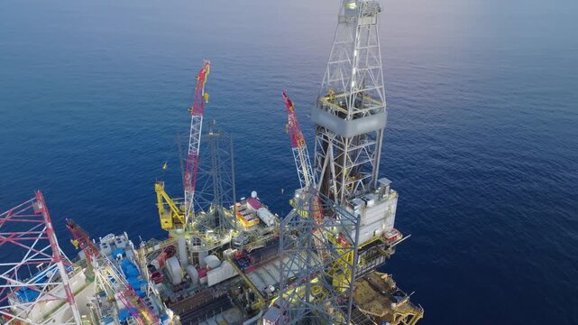 Offshore drilling rig - jack up and offshore platform during sunset for oil and gas exploration and production. 