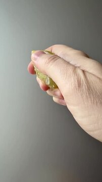 Hand Squeezing Juice From a Fresh Lime Vertical