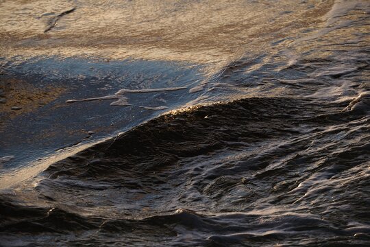 Dark Ocean Water Texture with Warm Golden Reflections