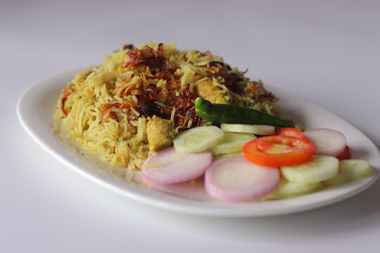 Chicken pulao with fragrant basmati rice, tender chicken pieces, fried onions and fresh salad