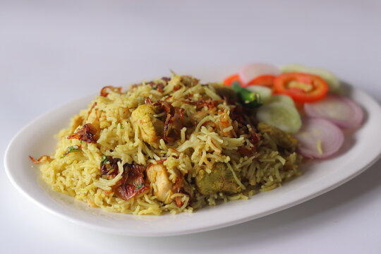 Chicken pulao with fragrant basmati rice, tender chicken pieces, fried onions and fresh salad