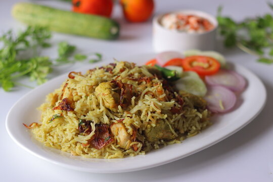 Chicken pulao with basmati rice, tender chicken, fried onions, fresh salad and yogurt side