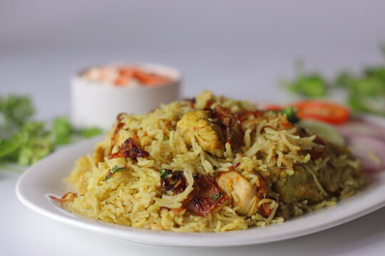Chicken pulao with basmati rice, tender chicken, fried onions, fresh salad and yogurt side