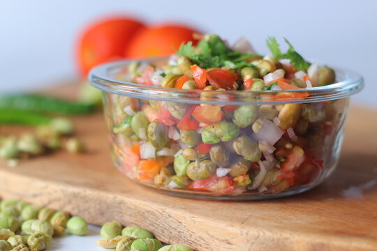 Roasted edamame bean salad with tomato, onion, carrot and fresh coriander in a glass bowl