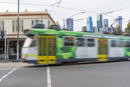 Commuter train speeding round corner in an urban streetscape