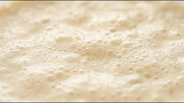 Food science fermentation appears as a creamy ivory culture of microscopic bubbles within a soft abstract material background