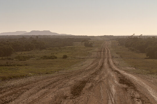 Hazy, dusty view of a dirt road with Mt Slowcombe in the distance